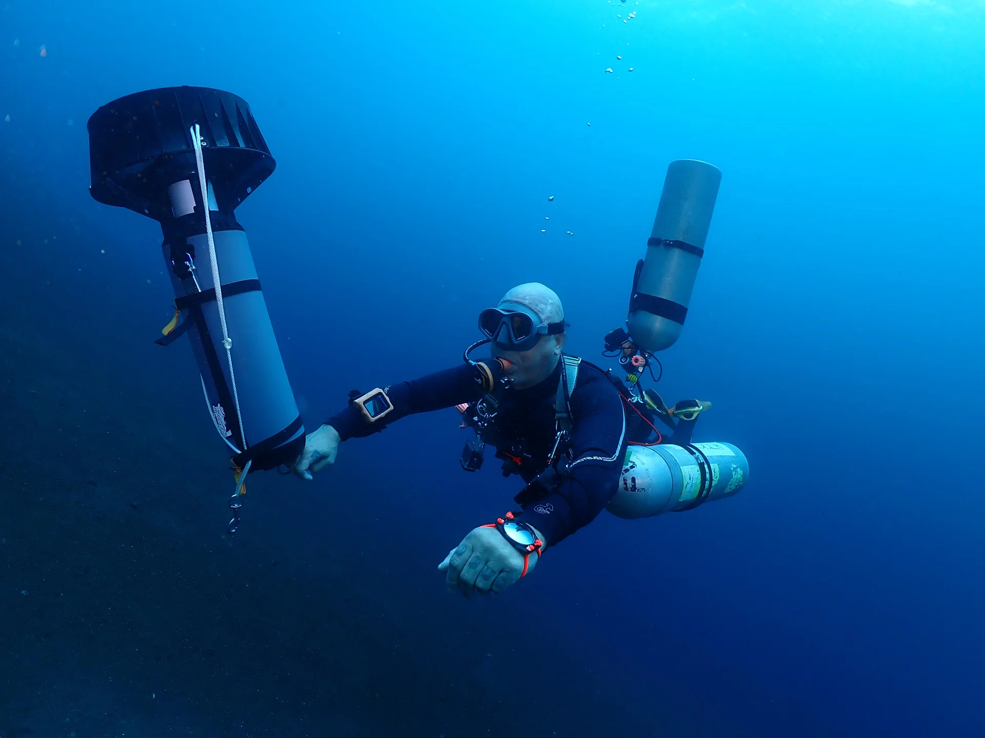 Technical diver on deco stop with twin cylinders and DSMB